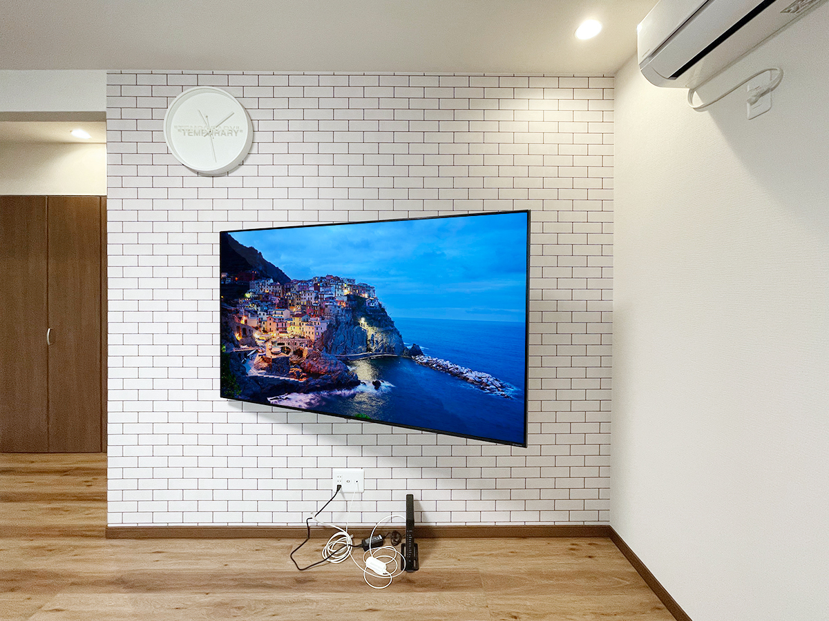 愛知県小牧市でアクセントクロスが貼られた石膏ボード壁にLGの65インチ