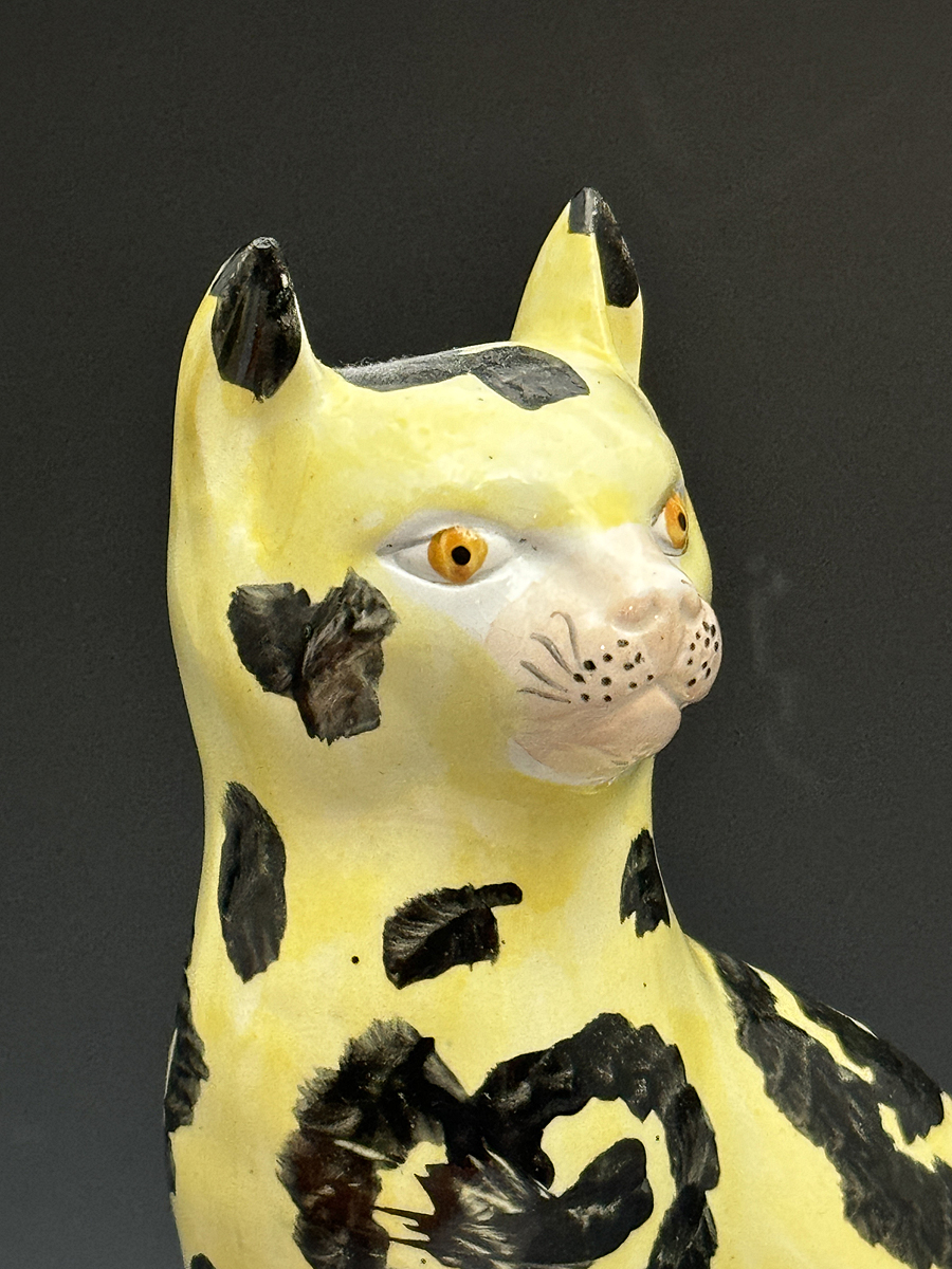 Staffordshire pottery black and yellow coloured figure of a seated