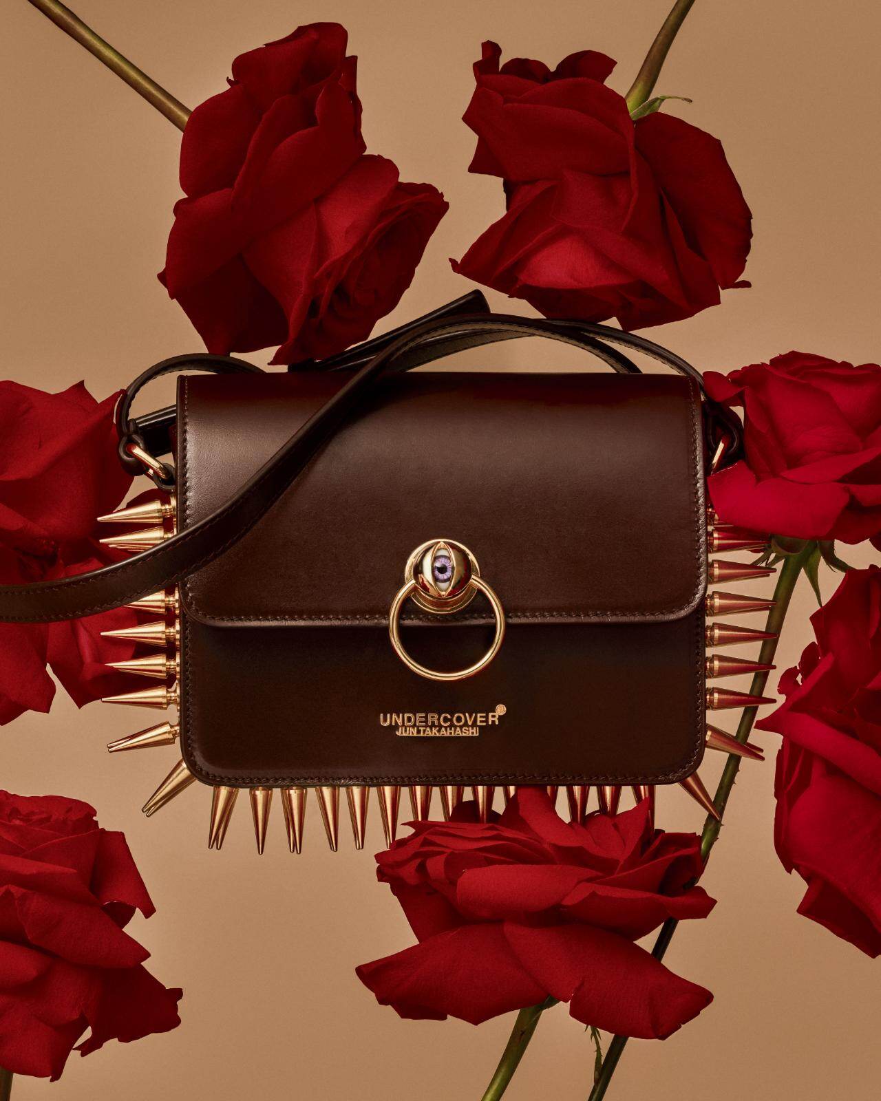 アンダーカバー“目玉”クラスプのレザーショルダーバッグ、大胆なメタル