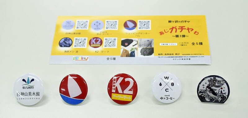 鯵ケ沢のご当地バッジ、新青森駅に販売機 就労支援事業所で製造｜なび