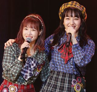 盟友の田島芽瑠（右）と肩を組んで笑顔を見せる朝長美桜＝2019年12月