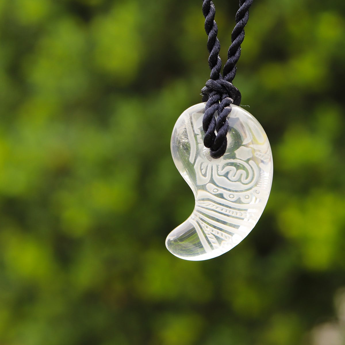 青空に映し出される縄文文様の勾玉水晶ペンダント（659-268