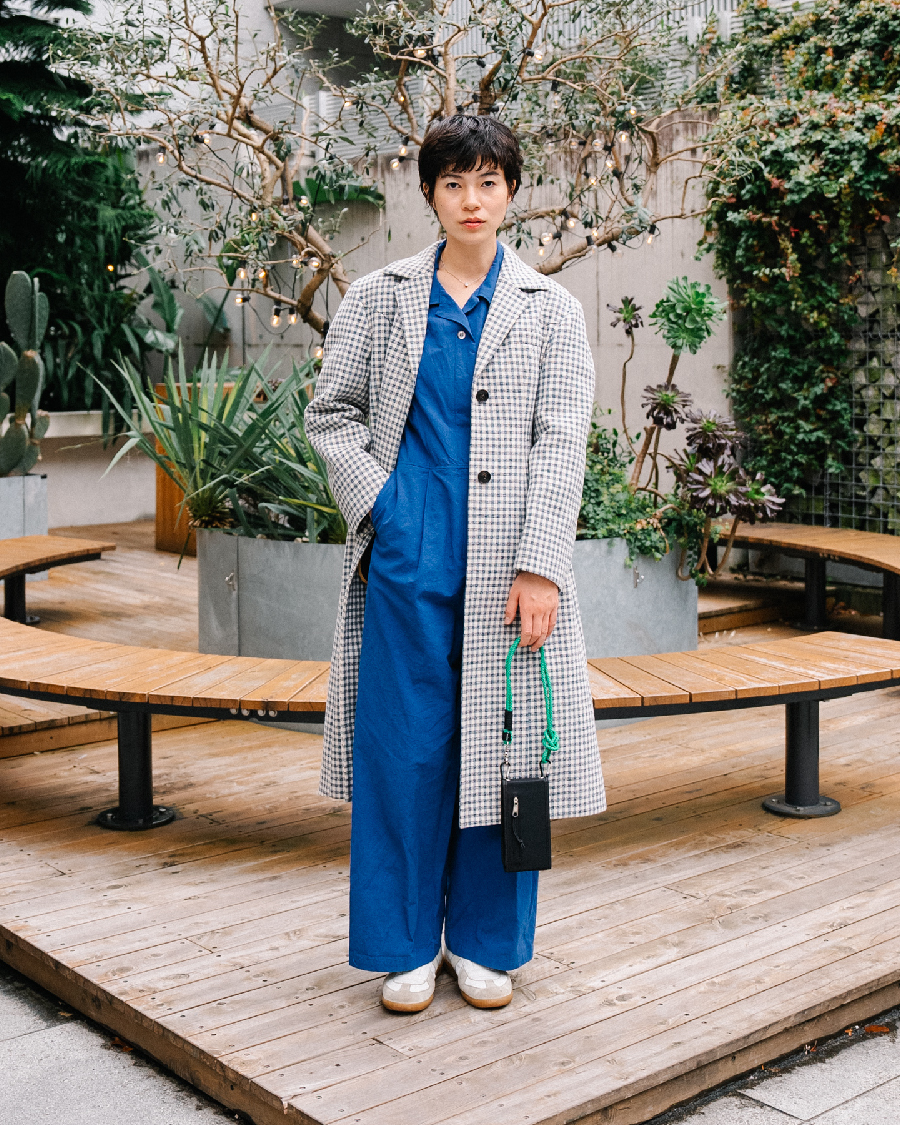 あざやかなブルーのジャンプスーツを主役に、チェックコートをあわせて