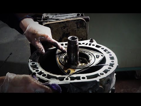 A man will disassemble the rotary engine that emits white smoke