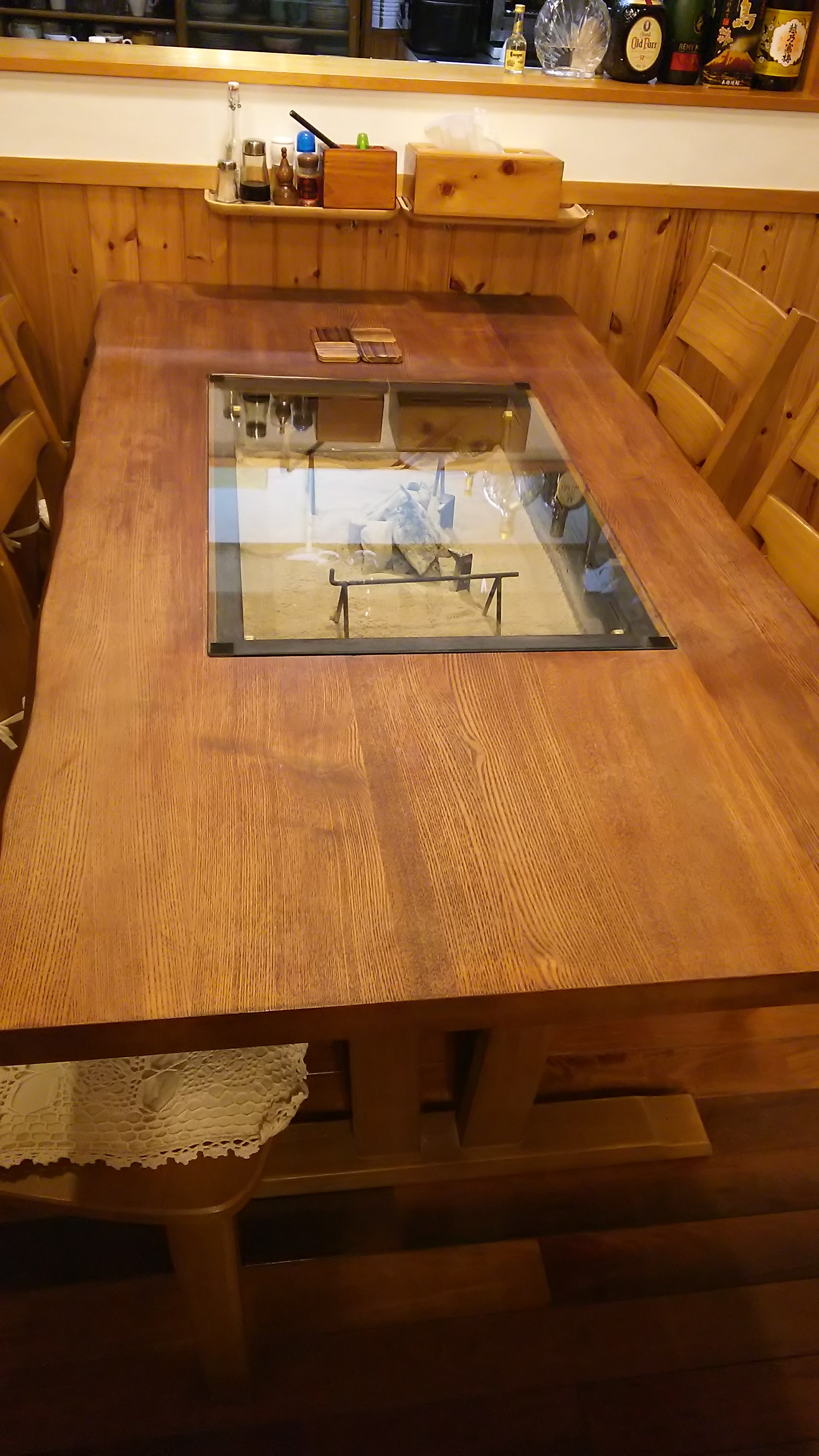 木のぬくもりを感じるテーブルの上にガラスを置かれたお客様（岐阜県